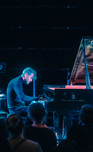 DeLange piano spelend op podium staande afbeelding