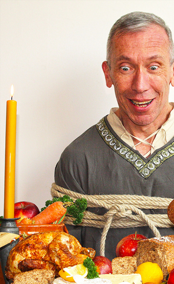 Frank Belt vastgebonden met eten voor voorstelling Op Verhaal staande afbeelding
