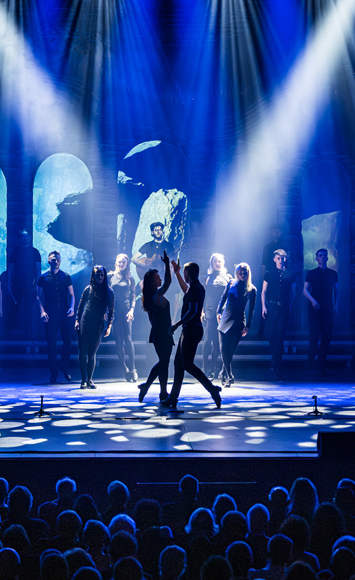 Rhythm of the Dance optreden op podium met blauwe lichten staande afbeelding